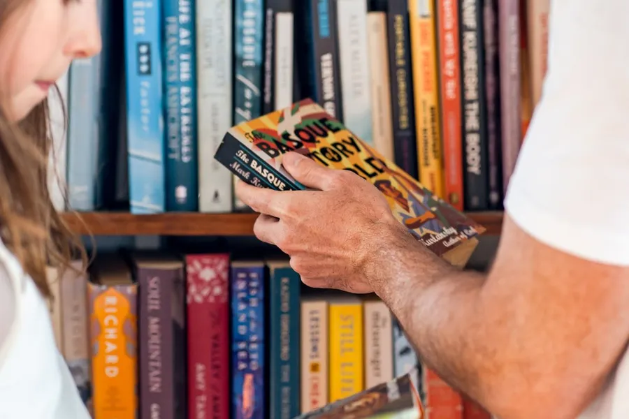 An adult and a child reading a picture book together indoors