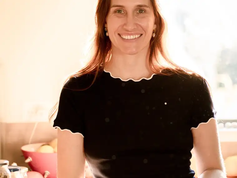 A clinician relaxed by a sunlit window in a warm home interior
