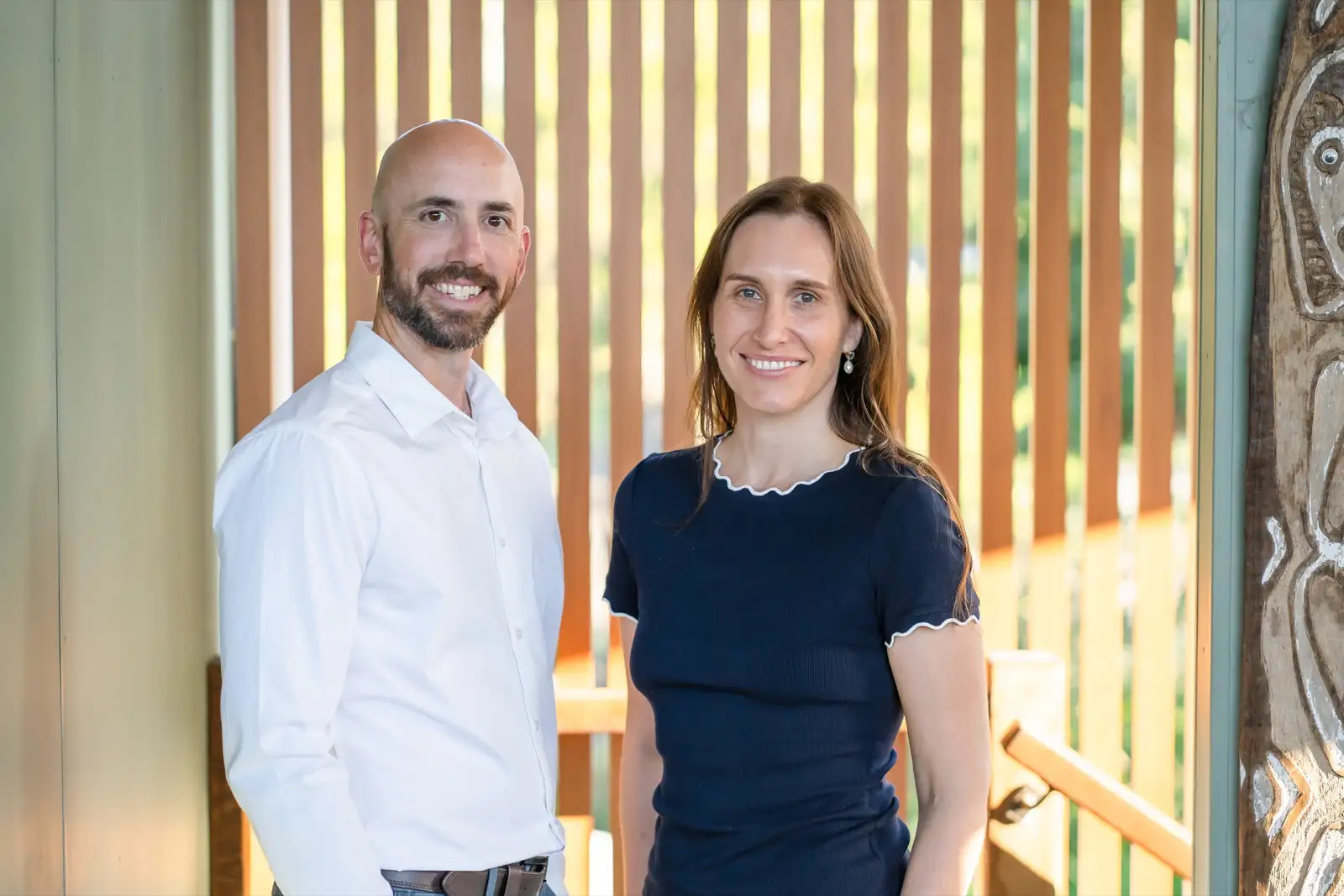 Two Constellation Therapies clinicians standing together by a warm timber screen in natural light