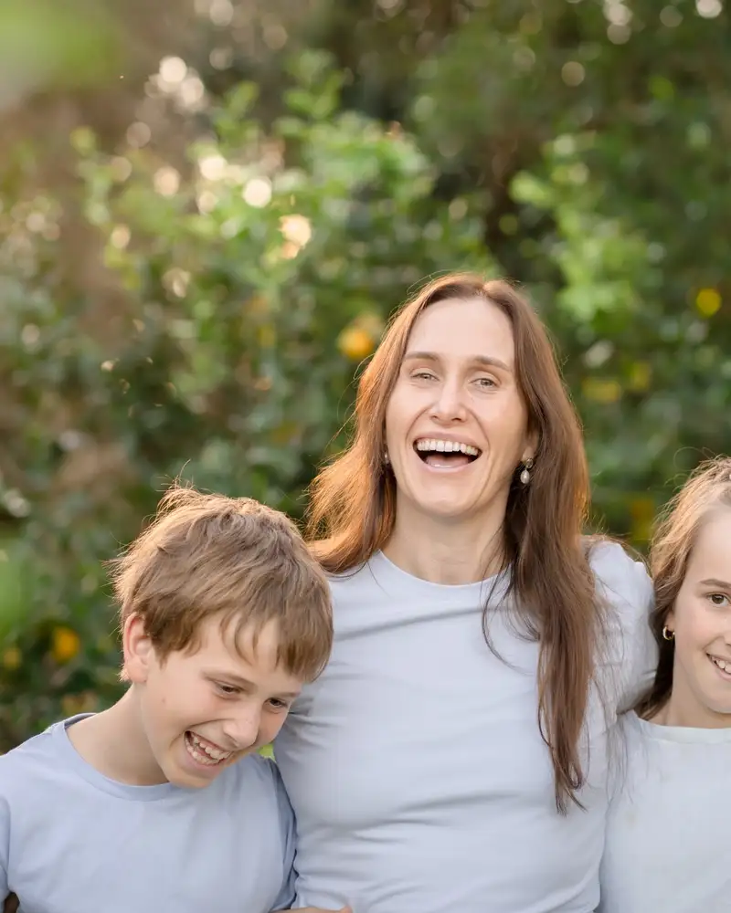A family standing together outdoors in warm afternoon light