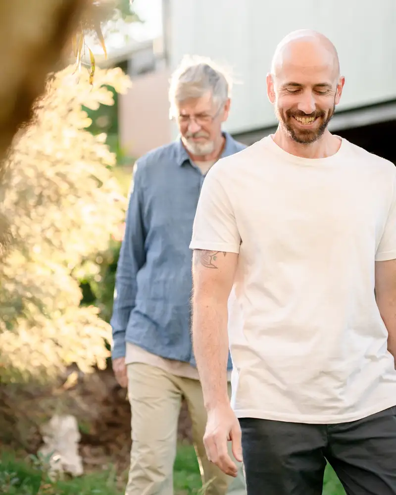 Two colleagues walking and talking together in a sunlit garden