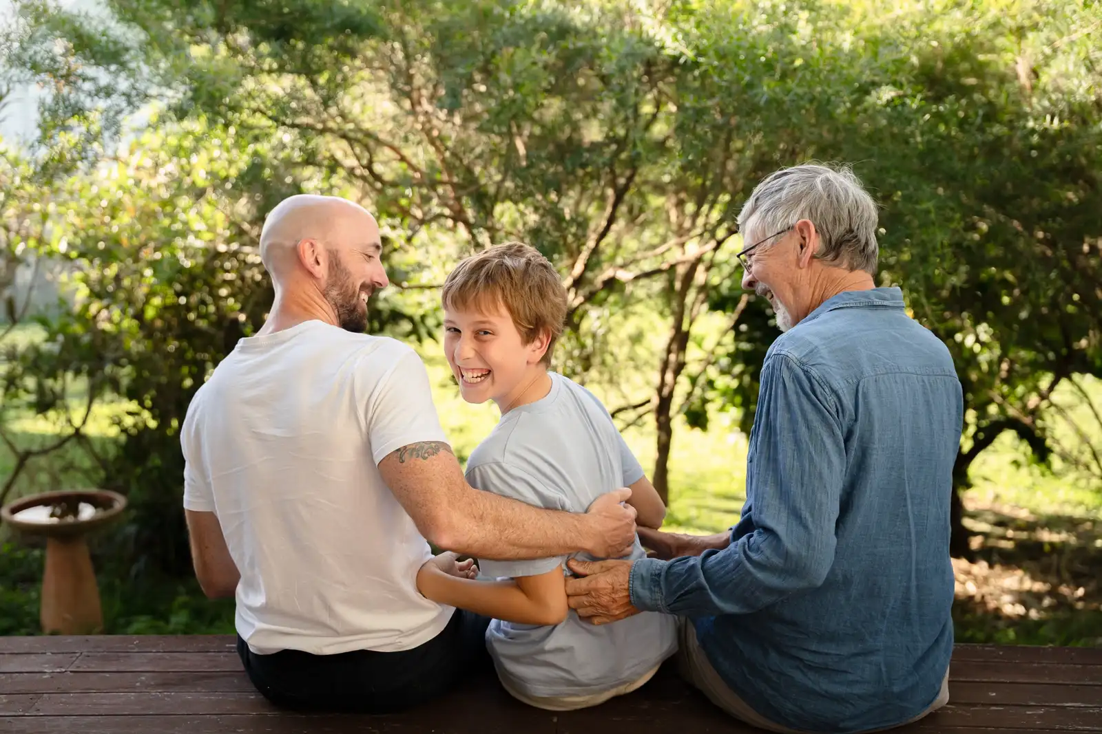 Family of different generations sitting together outdoors at golden hour