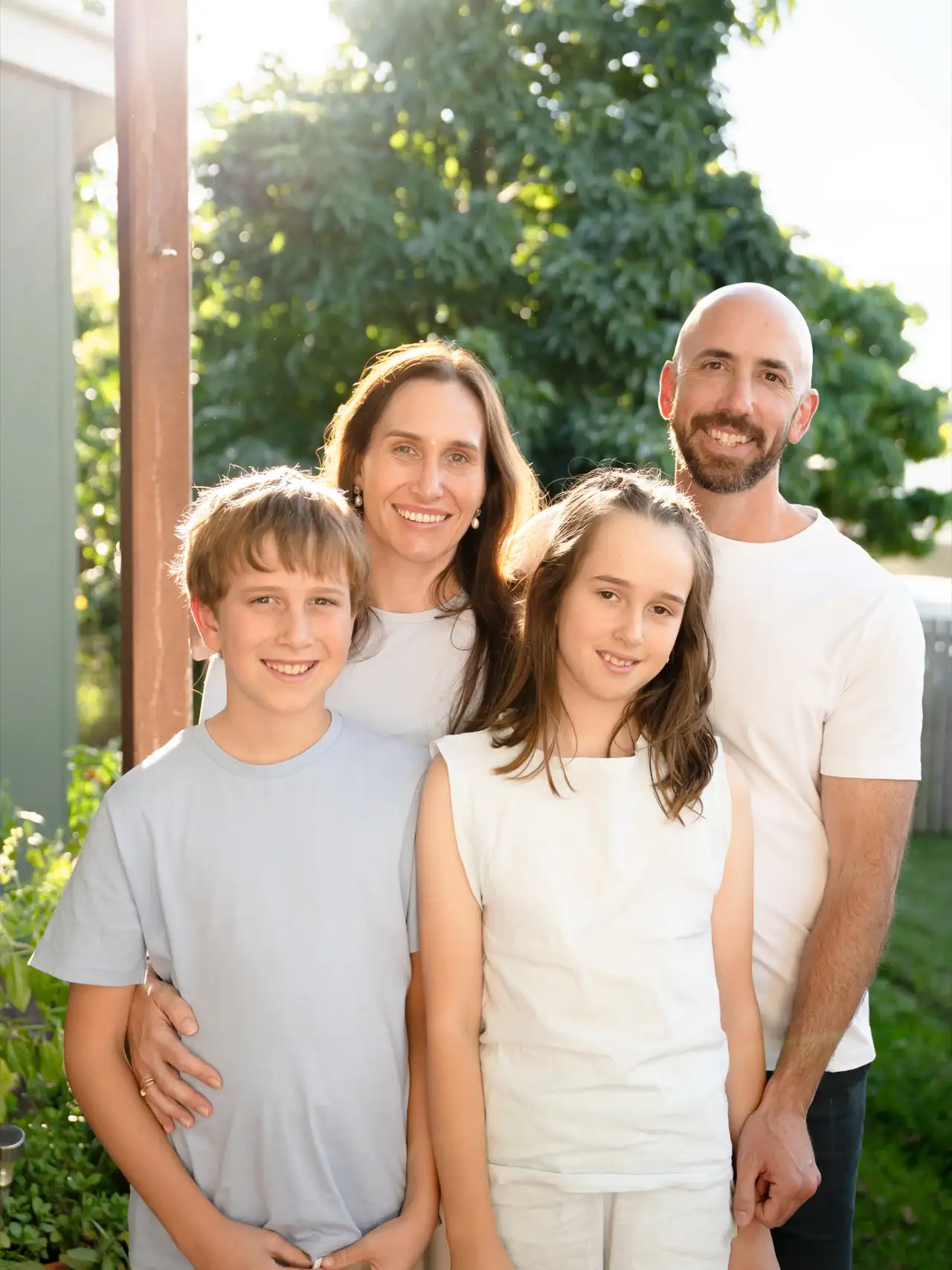 A family standing together in a sunlit garden at golden hour.