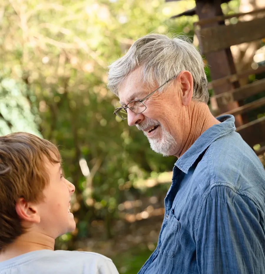 Two adults in conversation outdoors in warm afternoon light