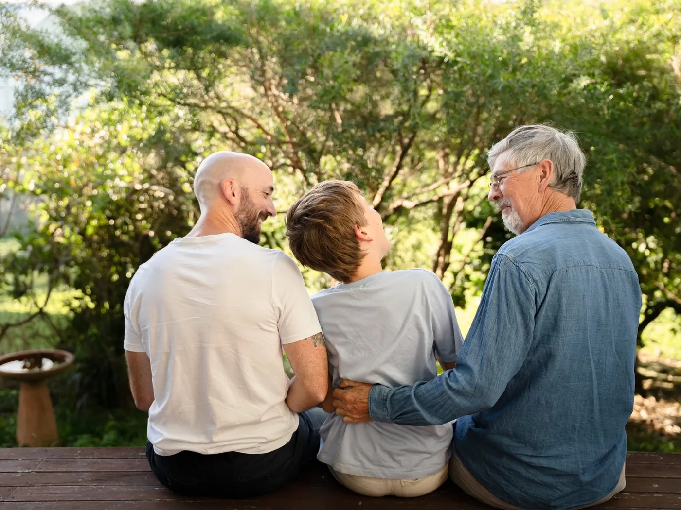 A family of three generations together outdoors in warm light