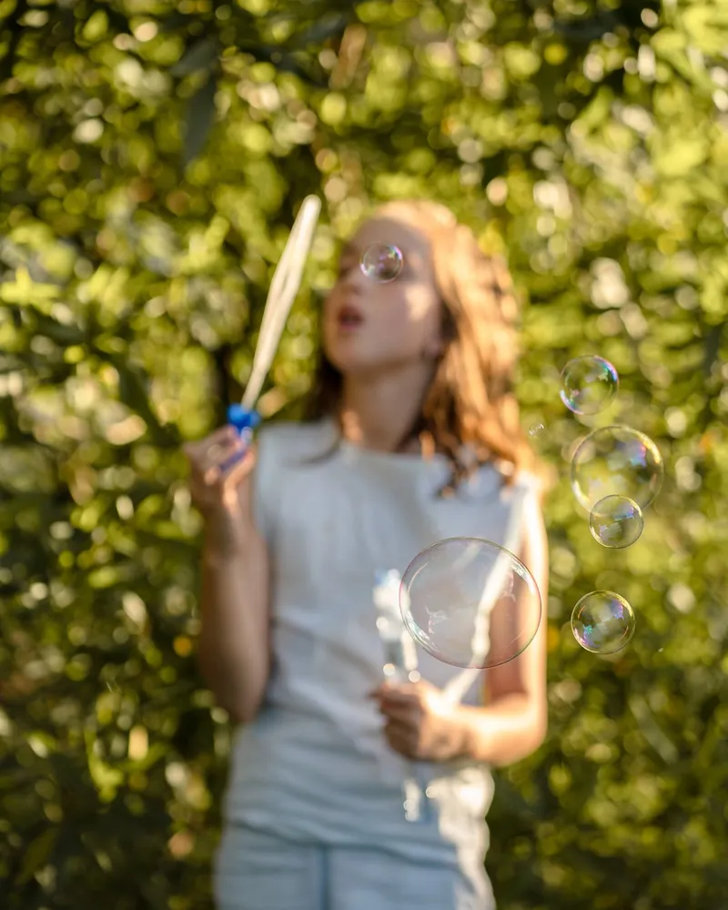 A teenager outdoors among the trees at golden hour